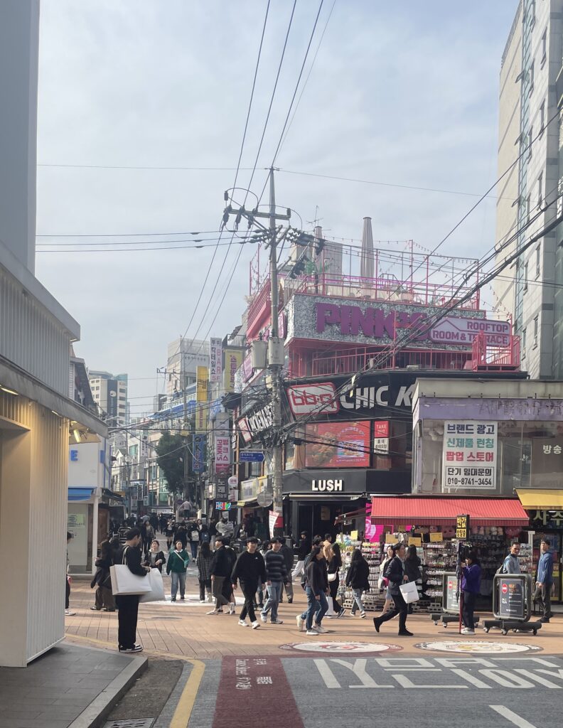 popular intersection with plenty of locals shopping, walking in Hongdae, Seoul 