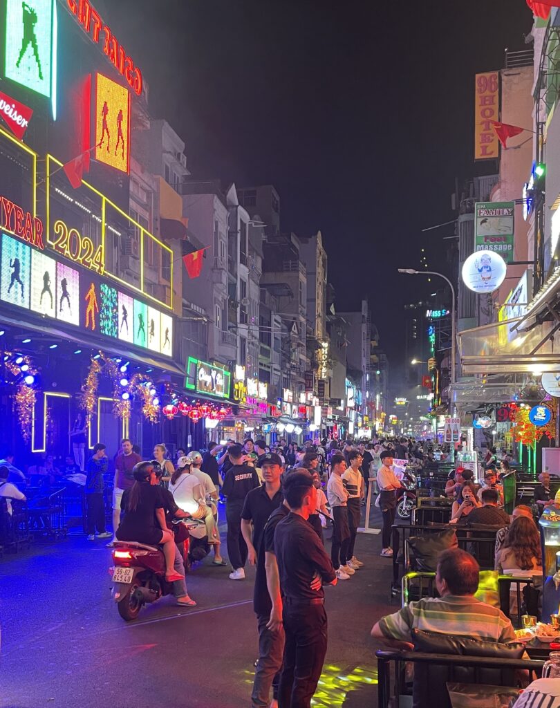 several locals and tourists walking, dining and partying on the famous Bui Vien Walking Street in Ho Chi Minh CIty at night