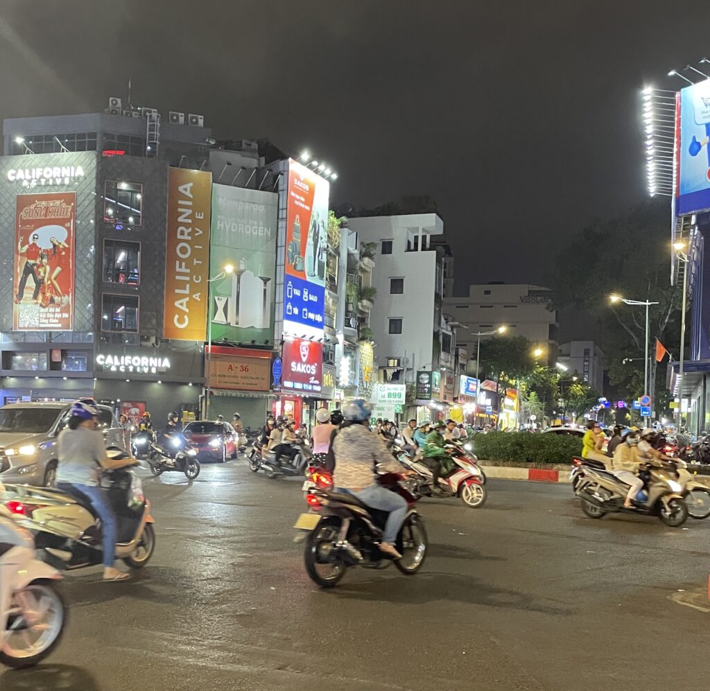 many scooters driving by in all directions in Ho Chi Minh City in the evening