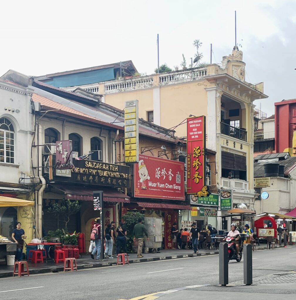a local man driving his scooter through Chinatown in Kuala Lumpur in the evening