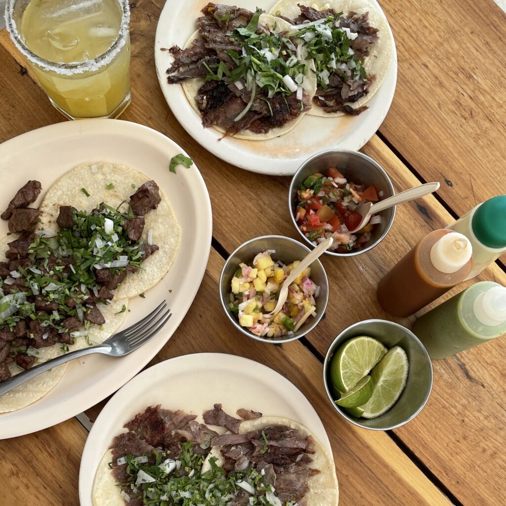 several tacos and a tequila drink being served at a restaurant in Playa Del Carmen, Mexico 