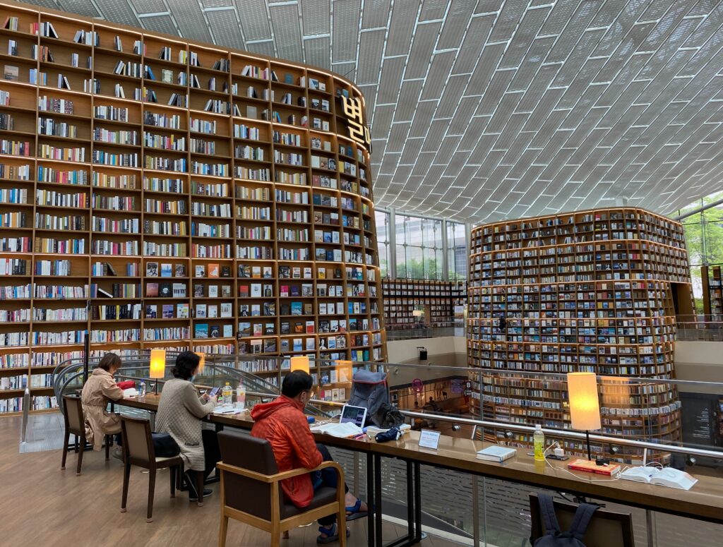 three locals studying amongst walls of books at the Starfield library in Gangnam, Seoul, Korea 