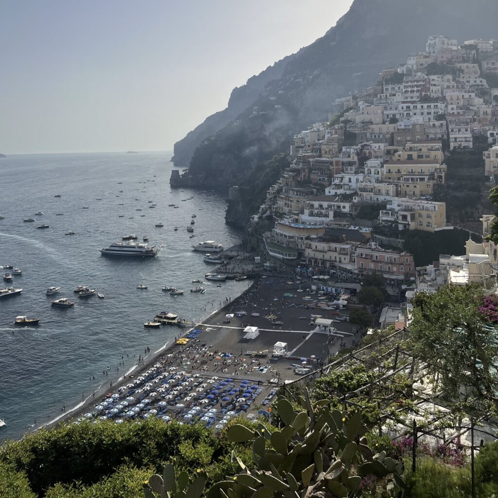 several tourist and boats around the Positano Beach during a Summer evening in Italy