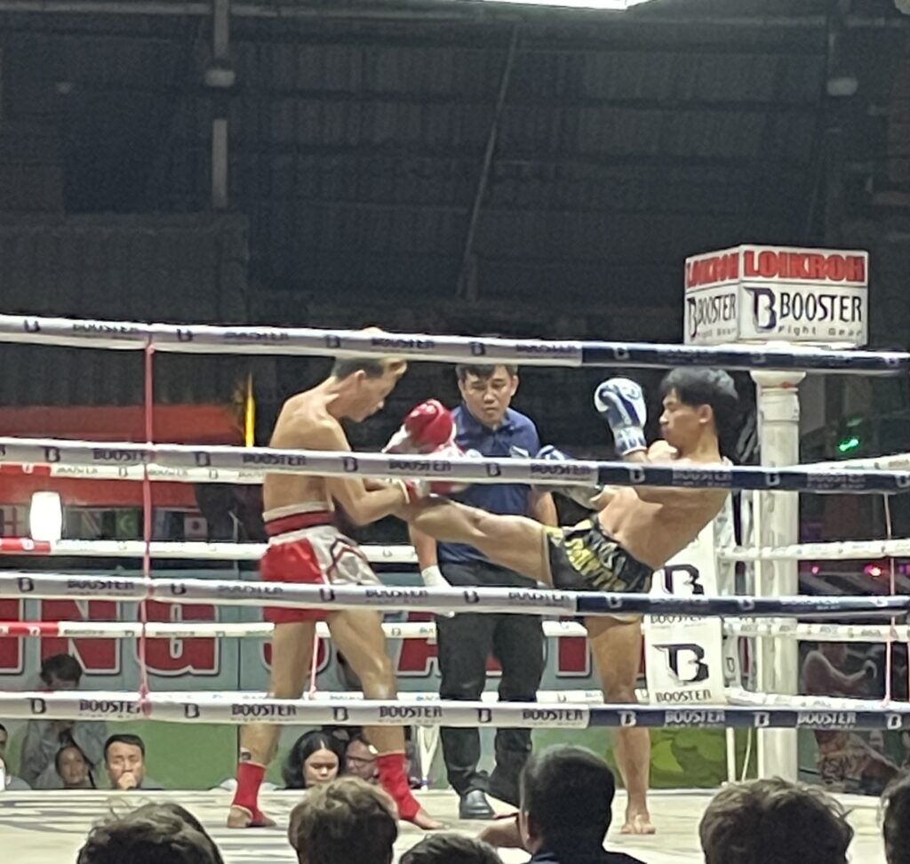 two men fighting muay thai style fighting in a ring in Chiang Mai, Thailand