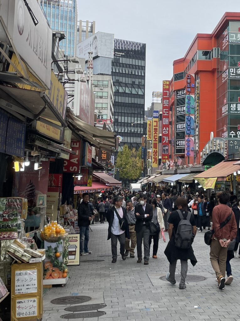 several locals walking around on a cloudy afternoon at the Namdaemun Market in Seoul