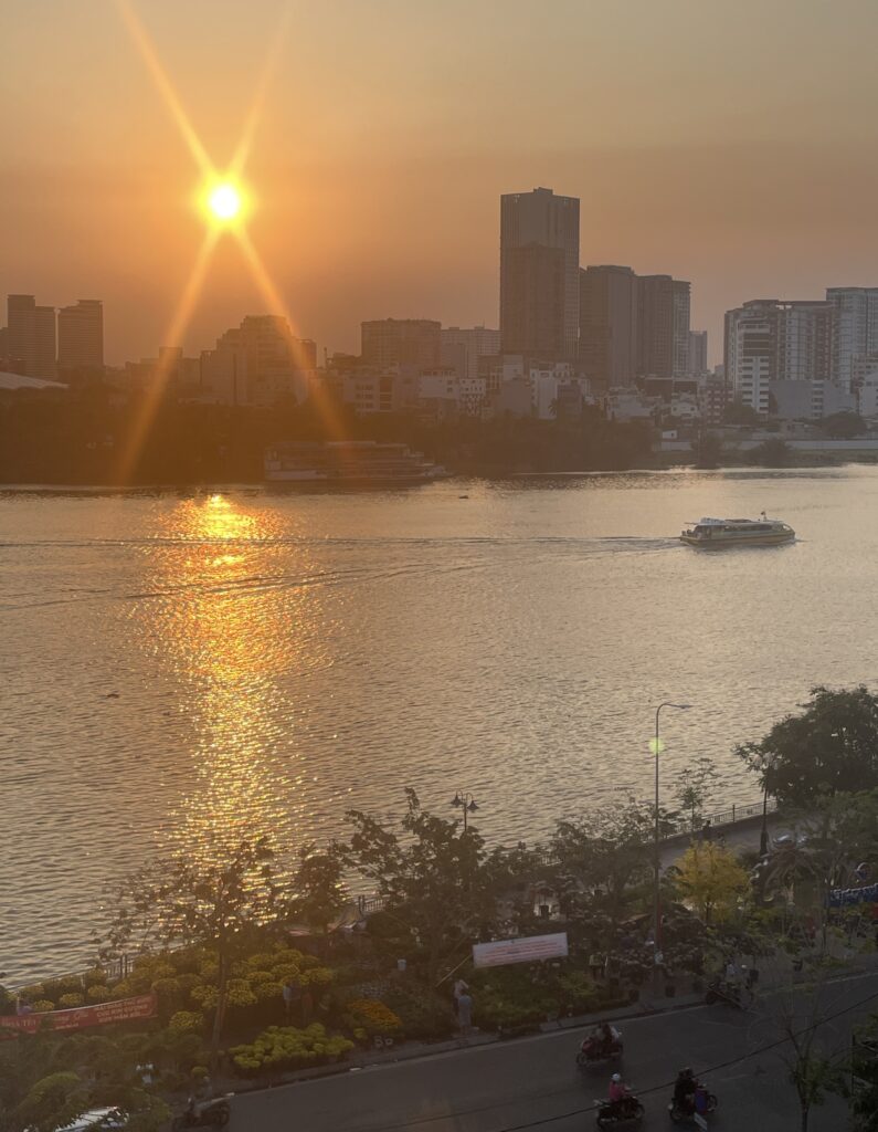views of a boat passing by in the Saigon River in Ho Chi Minh City during sunset 