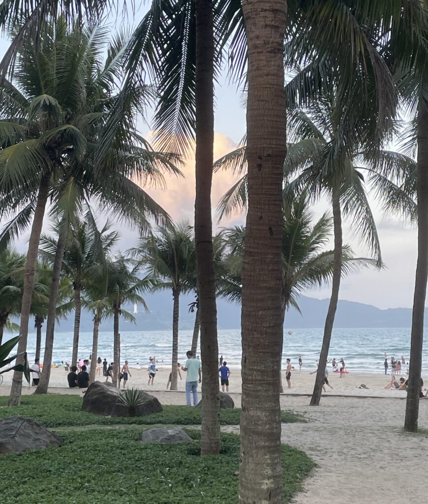 several locals and tourists on the beach at sunset in Da Nang 