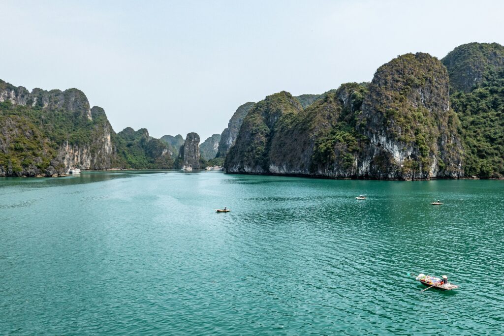 aerial shot of towering limestones on a local riding her boat in Halong Bay, Vietnam

