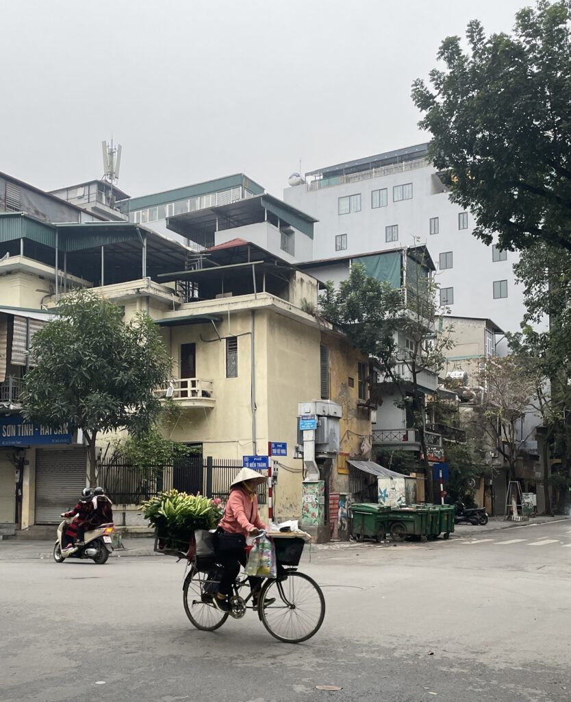 a local woman riding her bike in Hanoi 