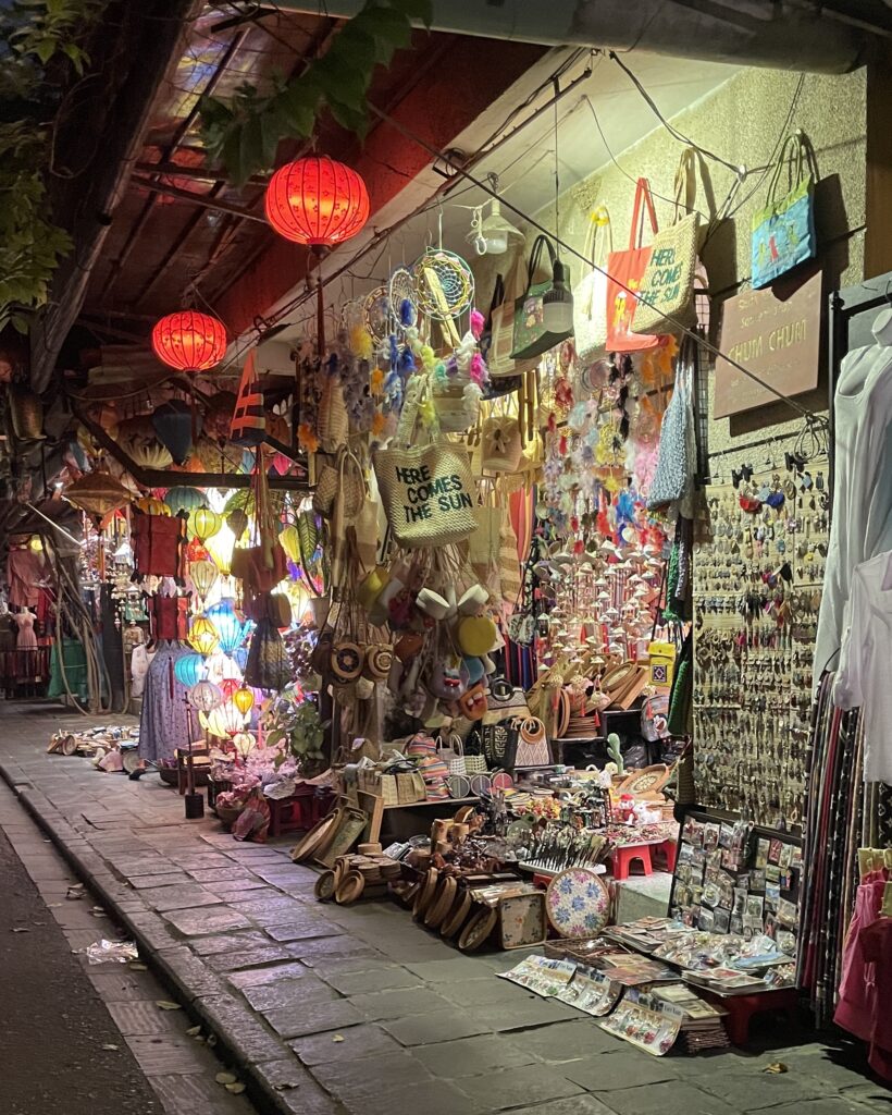several bags, magnets and other souvenirs sold at a street side shop in Hoi An
