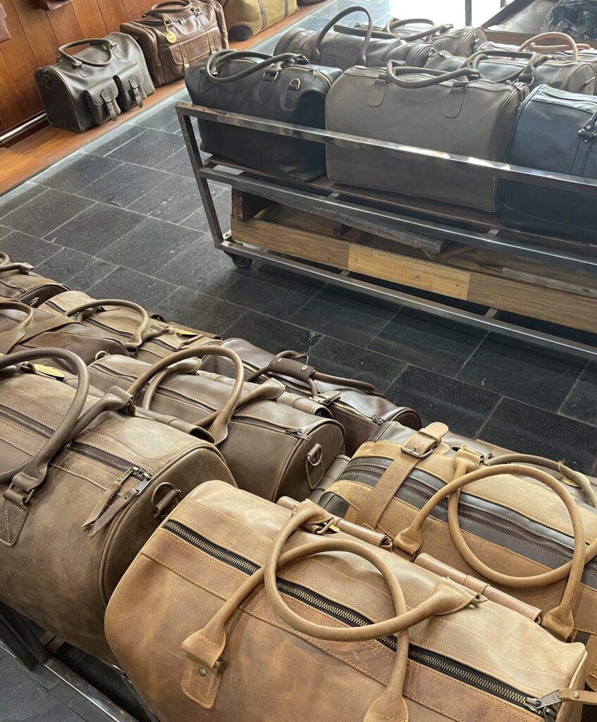 leather duffle bags, wallets and other leather goods at a shop in Hoi An