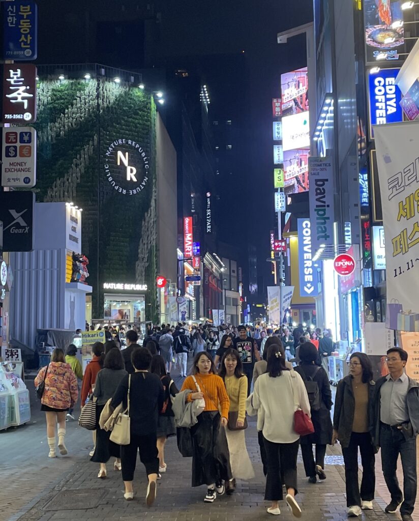 several locals and tourists walking at night in the Myeongdong area in Seoul, South Korea 