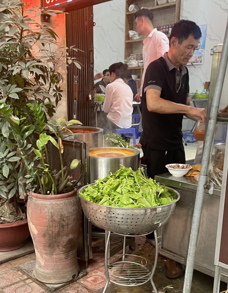 a man preparing onions at a pho restaurant 