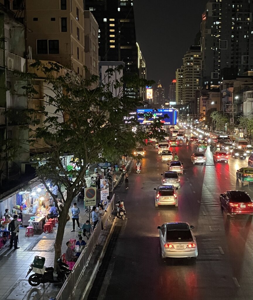 cars driving under an overpass at night in Bangkok