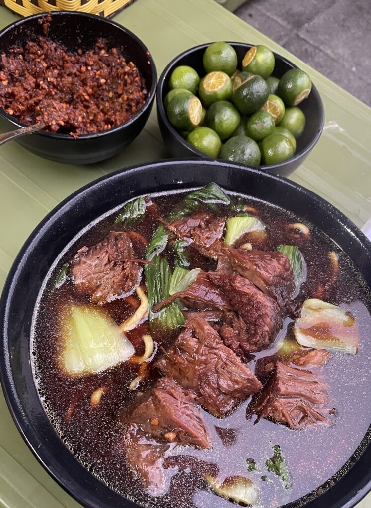 Taiwanese soup with lime and chilly being served on the side 