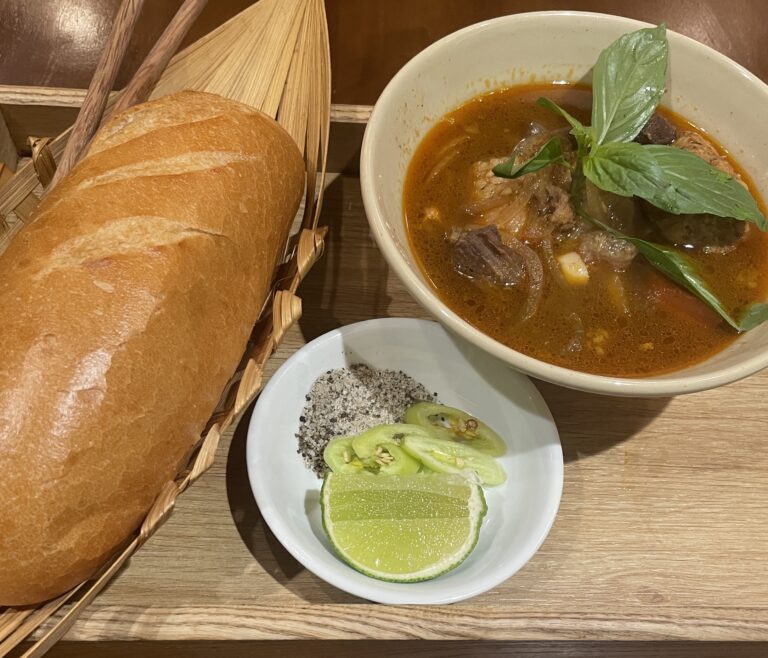 bo kho being served with a fresh baguette