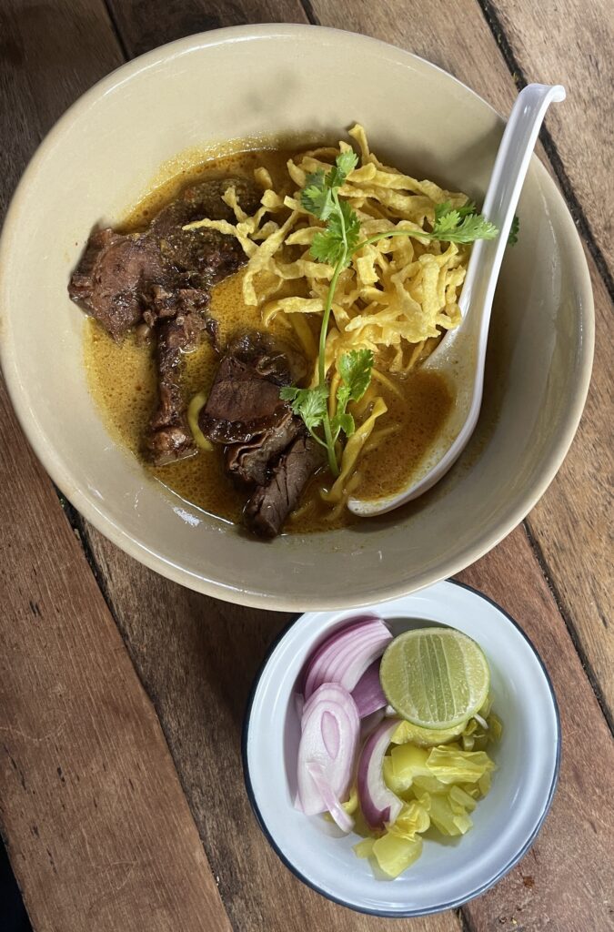 khao soi with a side of onion and pickled veggies 
