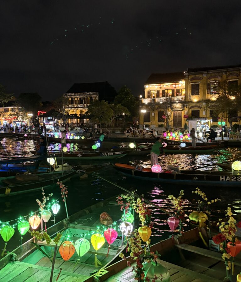 boats, lanterns and a backdrop of the yellow buildings at night in Hoi An