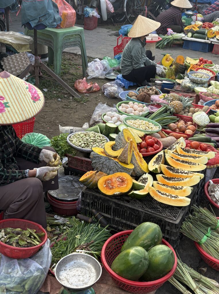 a few local Vietnamese women selling their produce at a local market 