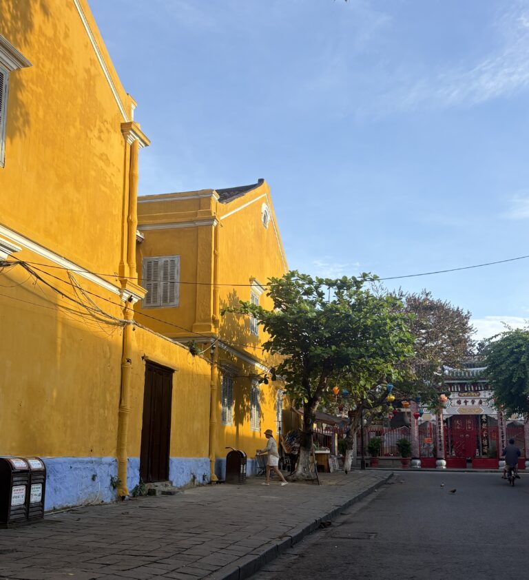 the sun hitting the bright yellow buildings in Hoi An in the morning