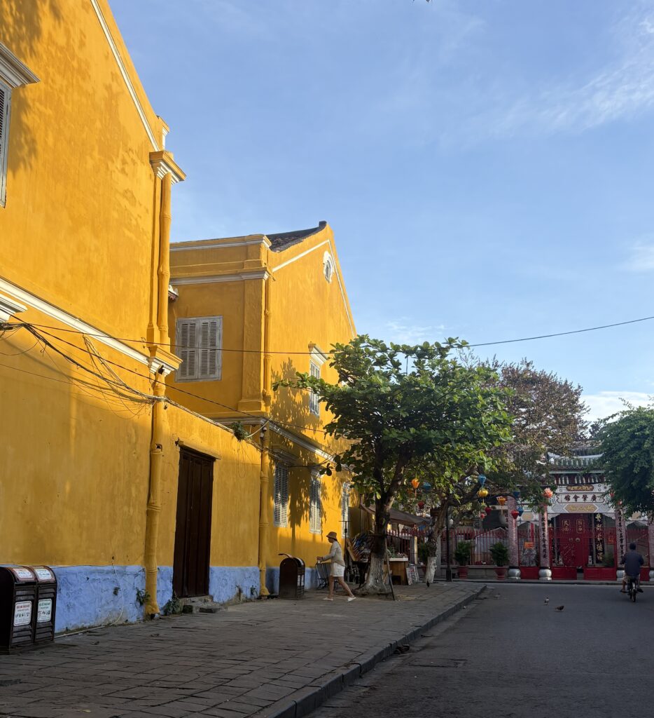 the sun hitting the bright yellow buildings in Hoi An in the morning