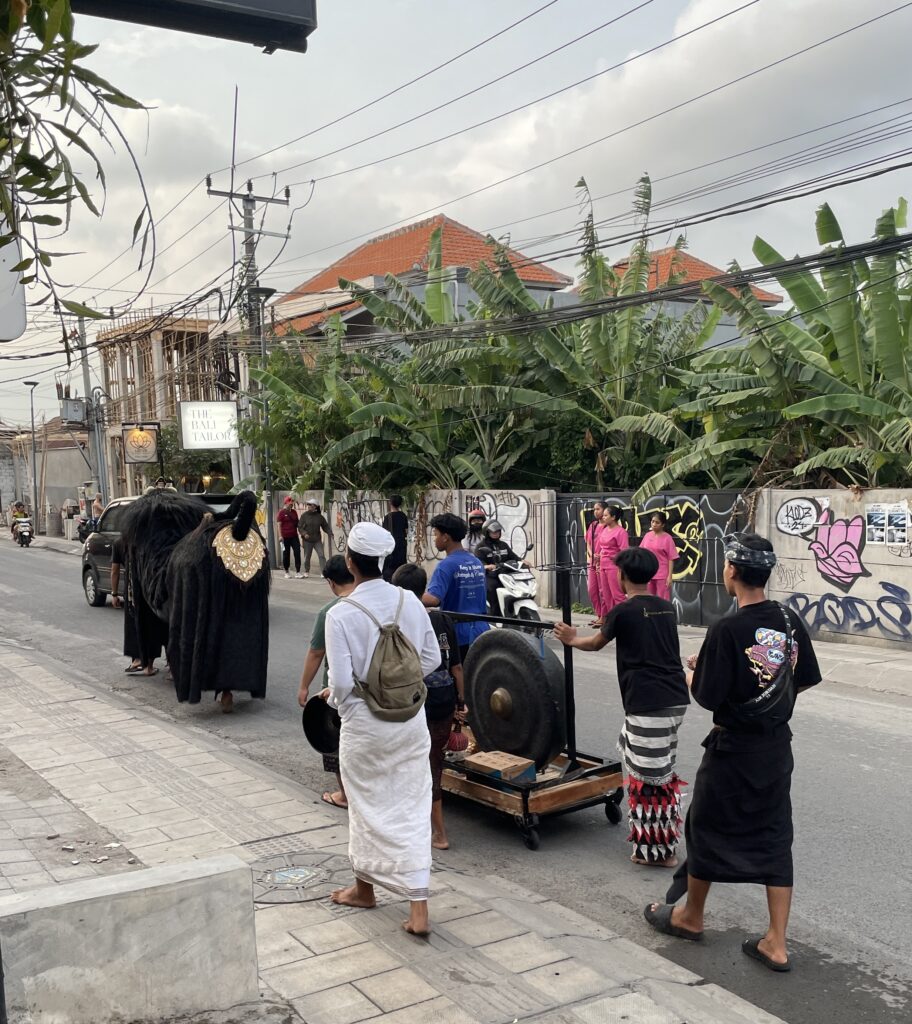 Balinese men dressed in traditional attire performing a cultural street ritual in Bali, Indonesia.

