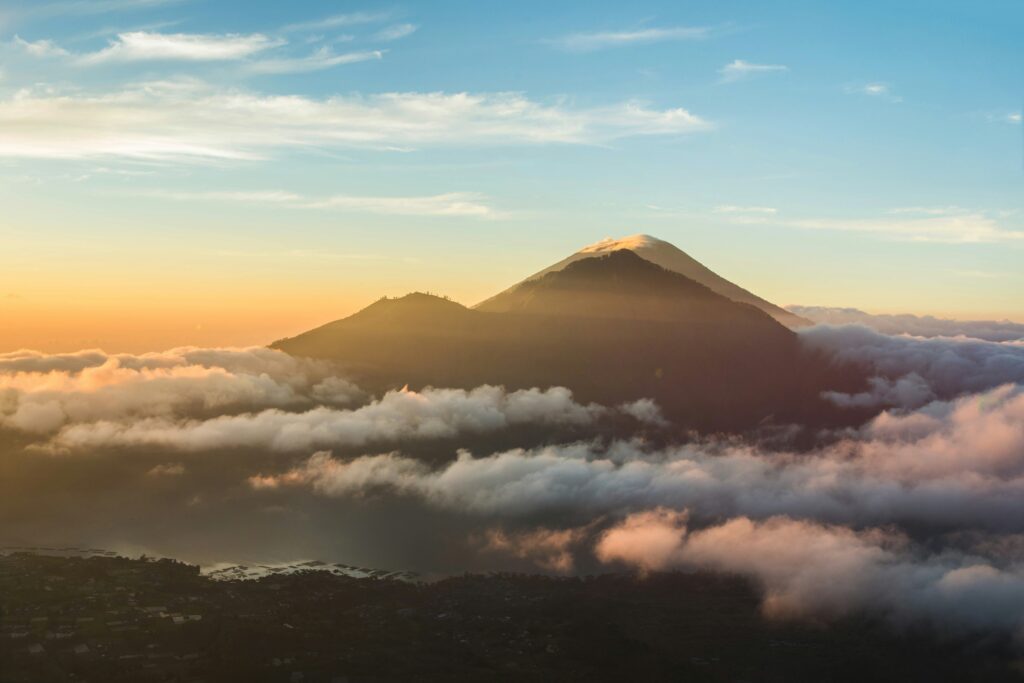 View from the summit of Mount Batur at sunrise, showcasing the volcanic landscape and morning mist in Bali.