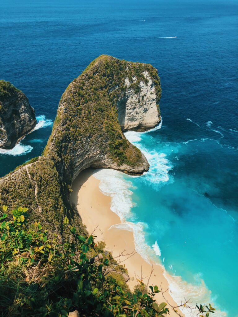 Stunning cliffside view of Kelingking Beach on Nusa Penida, Bali, with turquoise water and dramatic coastline