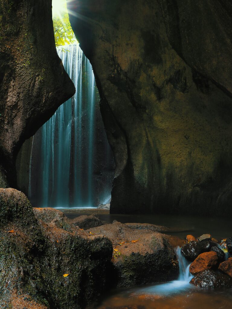 Sunlight streaming through the cave opening at Tukad Cepung Waterfall, one of Bali’s hidden gems