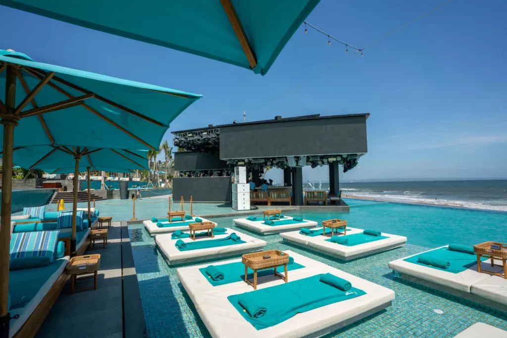 Vibrant atmosphere at Atlas Beach Club in Bali featuring sunbeds under bright tropical skies