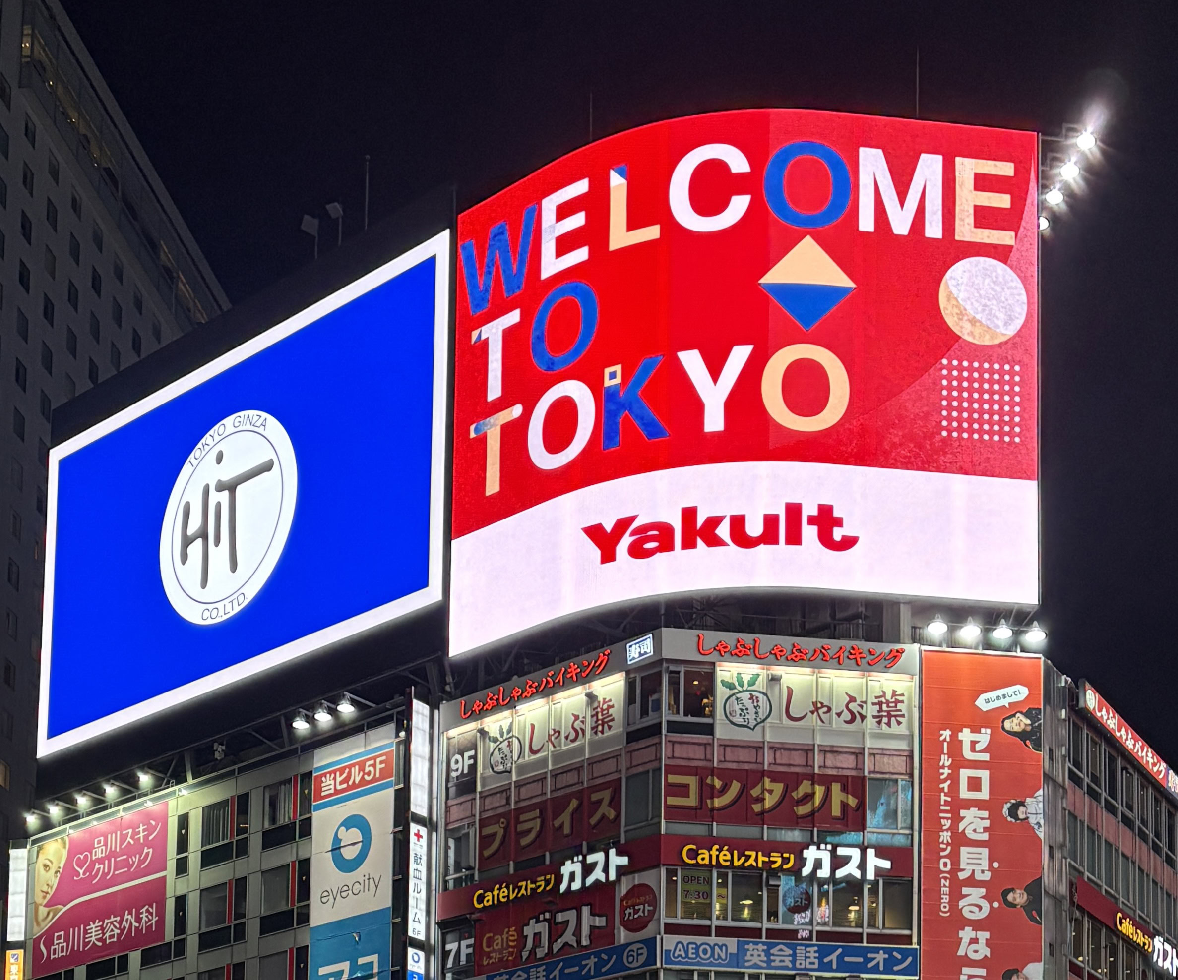 Shibuya Crossing at night with a Welcome to Tokyo sign, showcasing one of the best areas to stay in Tokyo