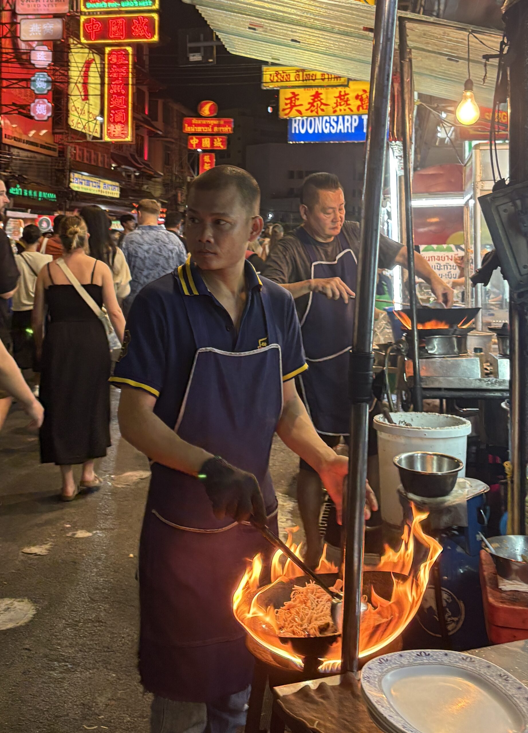 Street food vendor in Bangkok’s Chinatown cooking over a fiery wok a snapshot of Thailand’s energy and flavor.