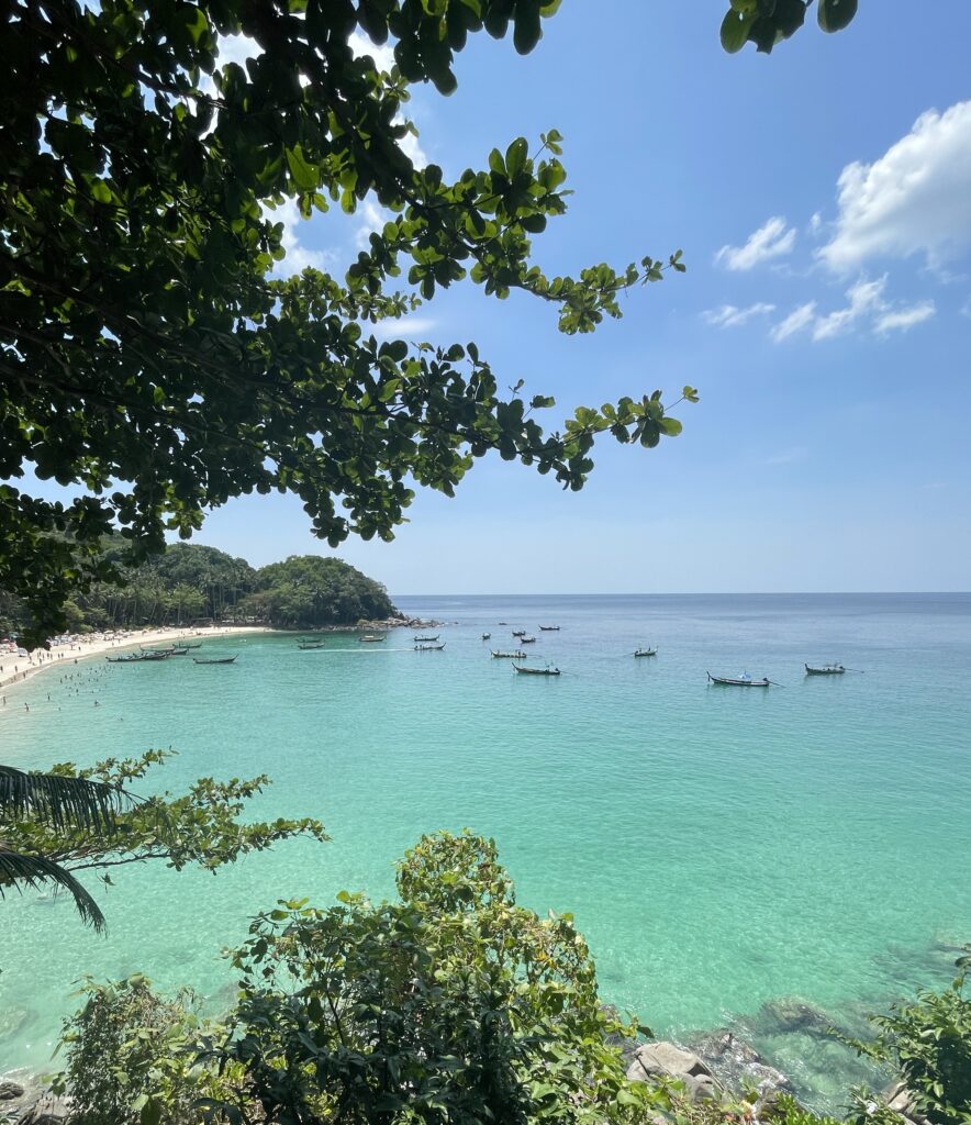 Stunning view of Freedom Beach in Phuket seen from hiking trail above, with turquoise water and lush greenery