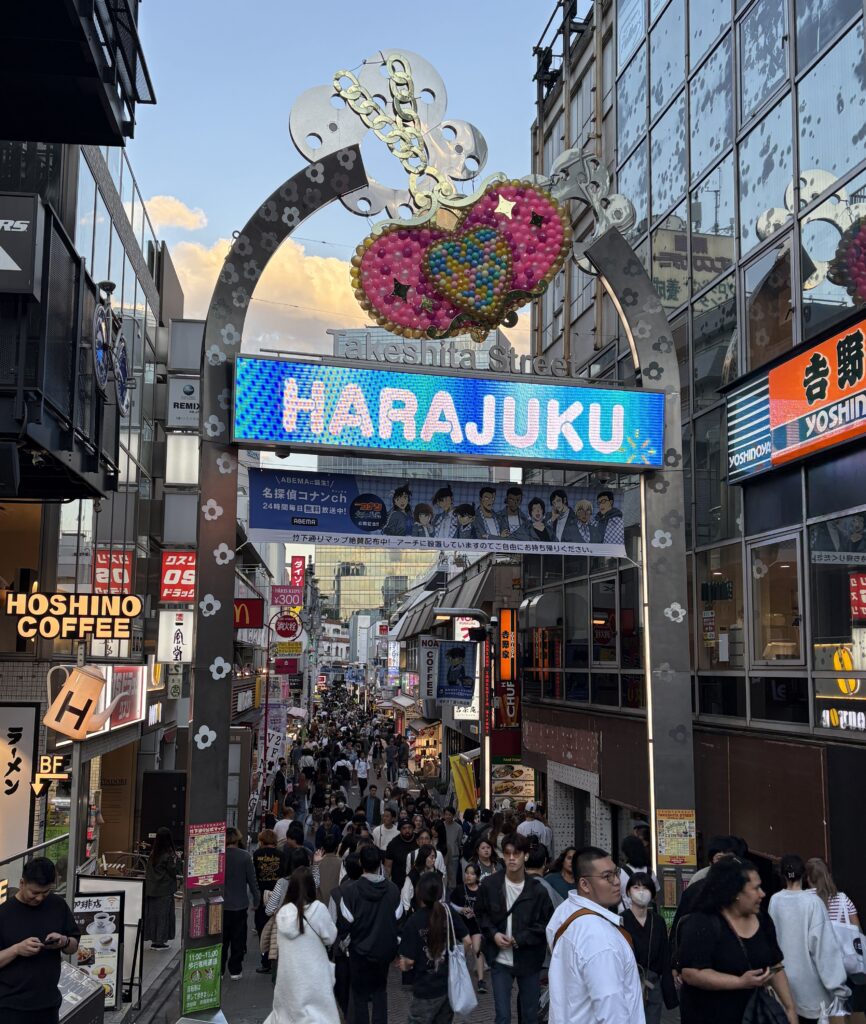 Crowds walking through Takeshita Street in Harajuku Tokyo under colorful signage