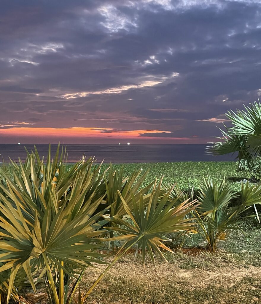 Vibrant purple and dark-hued sunset at Karon Beach in Phuket with gentle waves and colorful sky