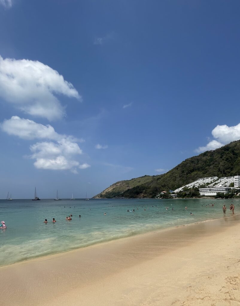 Nai Harn Beach in Phuket on a clear day with empty sand and crystal-clear waters