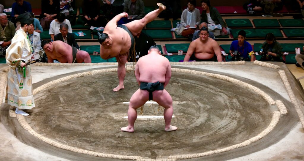 Sumo wrestlers practicing in a Tokyo training stable, showing traditional techniques and rituals