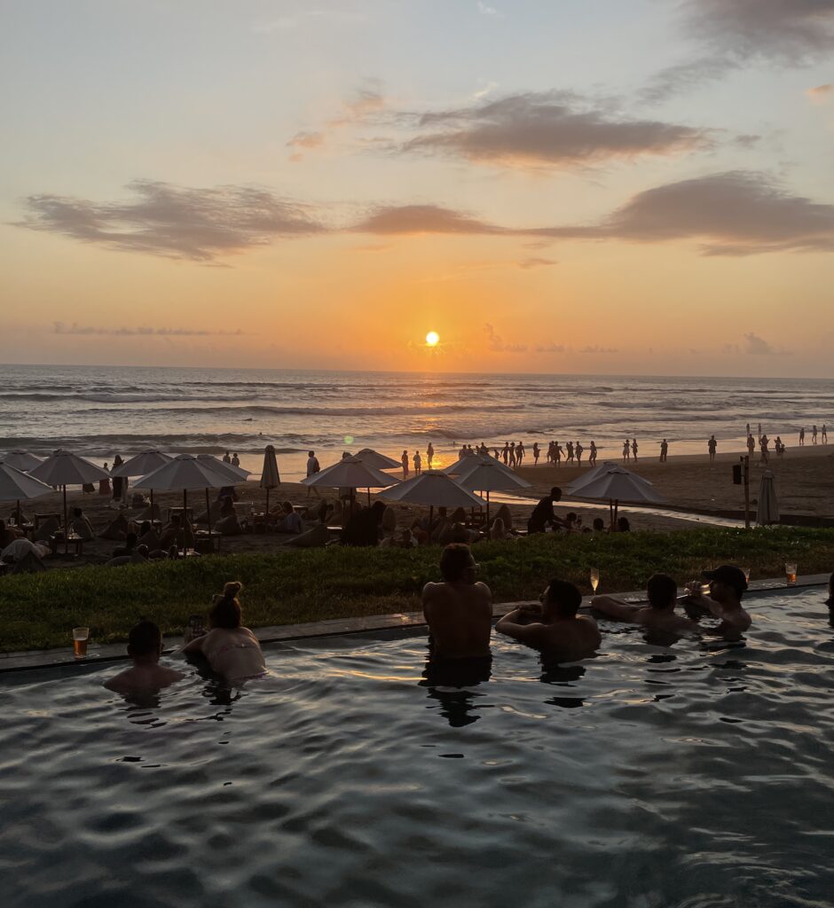 tourist in the pool during sunset at The Lawn Canggu beach club in Bali