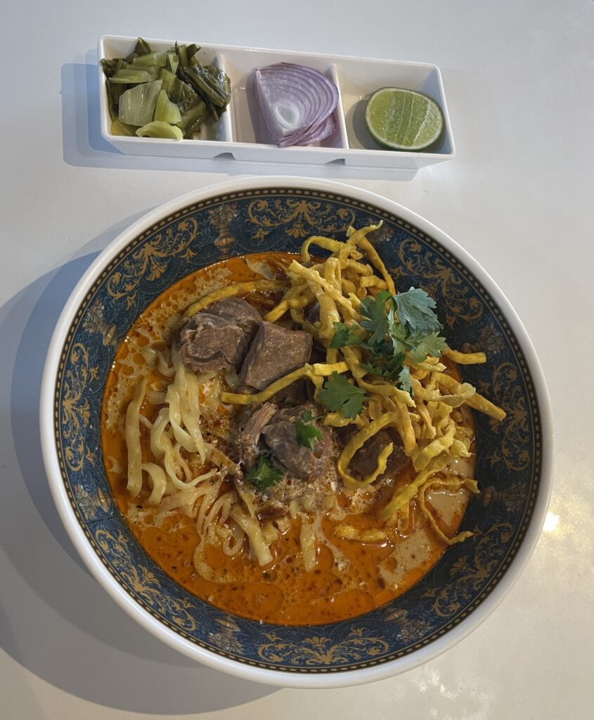 A perfectly served bowl of tender beef Khao Soi at Khao Soi Doi Nang in Chiang Mai, Thailand.