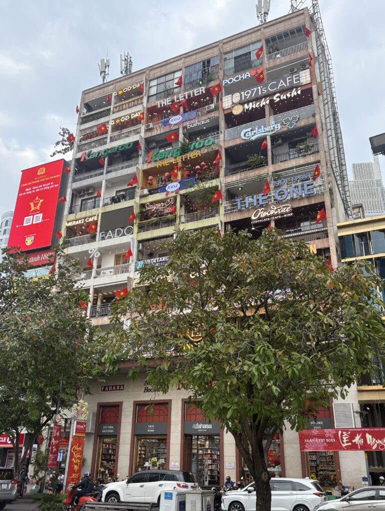 The iconic Cafe Apartment at 42 Nguyen Hue Street in Saigon, featuring stacked cafes and boutique stores overlooking the pedestrian boulevard.
