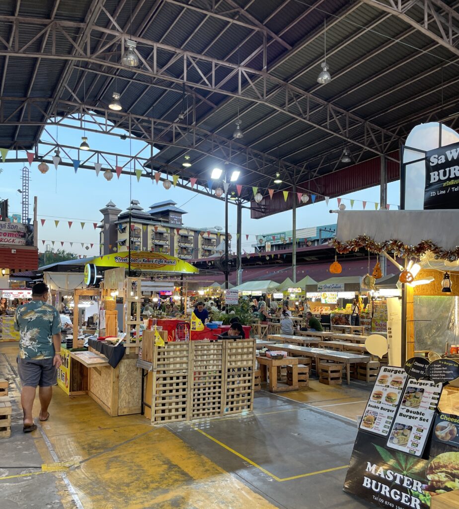 Chiang Mai Night Bazaar in the early evening as vendors begin setting up their stalls before the evening rush.
