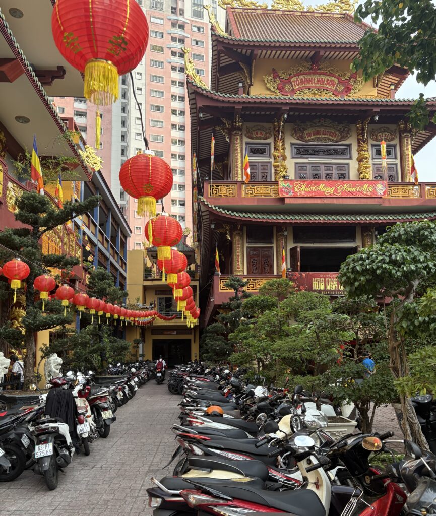 Traditional Chinese-style temple in District 5 of Ho Chi Minh City with ornate red pillars, lanterns, and intricate roof detailing