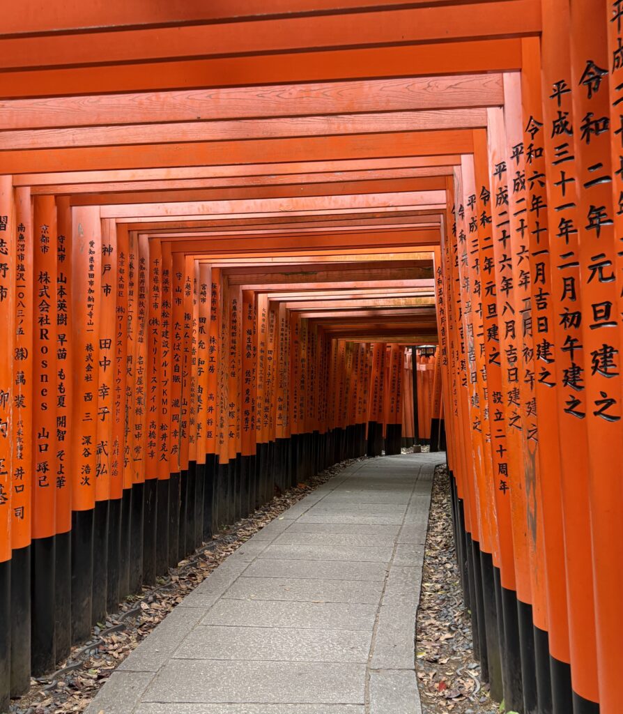 Close-up view of the red torii gate tunnel at Fushimi Inari Shrine in Kyoto, showcasing vivid color and immersive walkway perspective