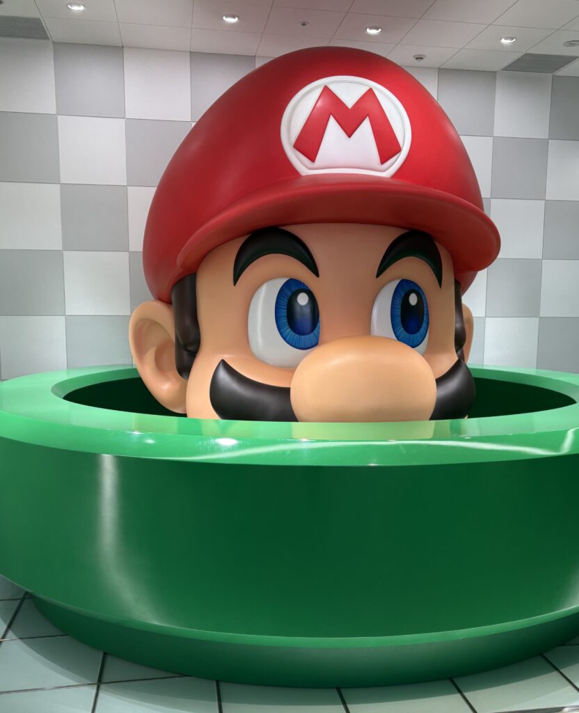 Giant Mario figure displayed outside the Nintendo Store in Kyoto, welcoming visitors with vibrant colors and playful energy.