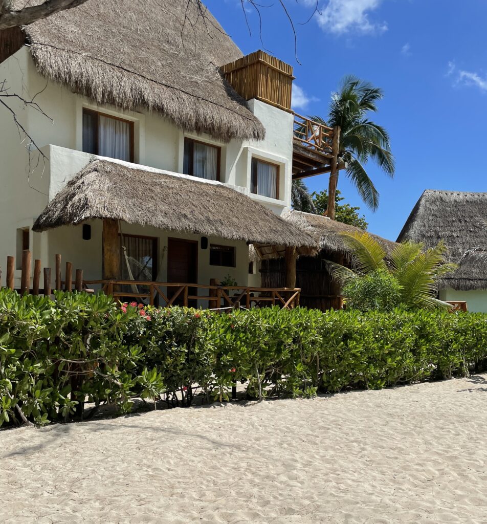 Beachfront hotel with a palapa-style roof in the Gonzalo Guerrero area of Playa del Carmen, sitting just steps from the sand and sea.
