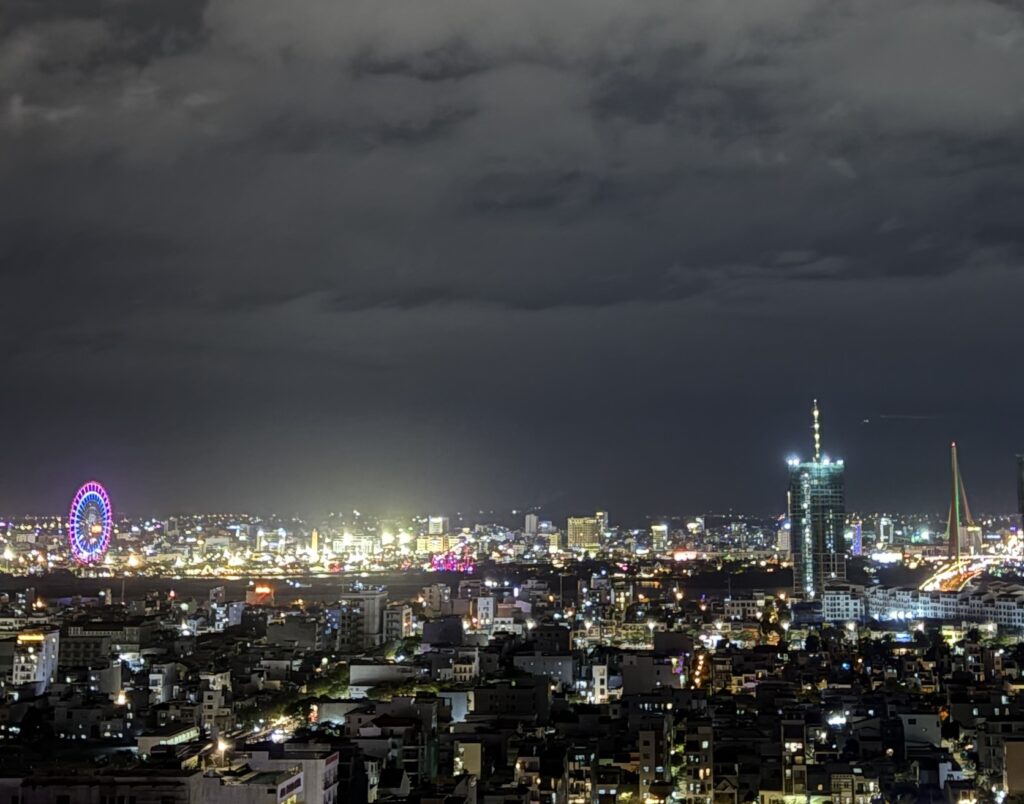 Panoramic nighttime view of Da Nang’s Han River with illuminated city skyline and reflections on the water
