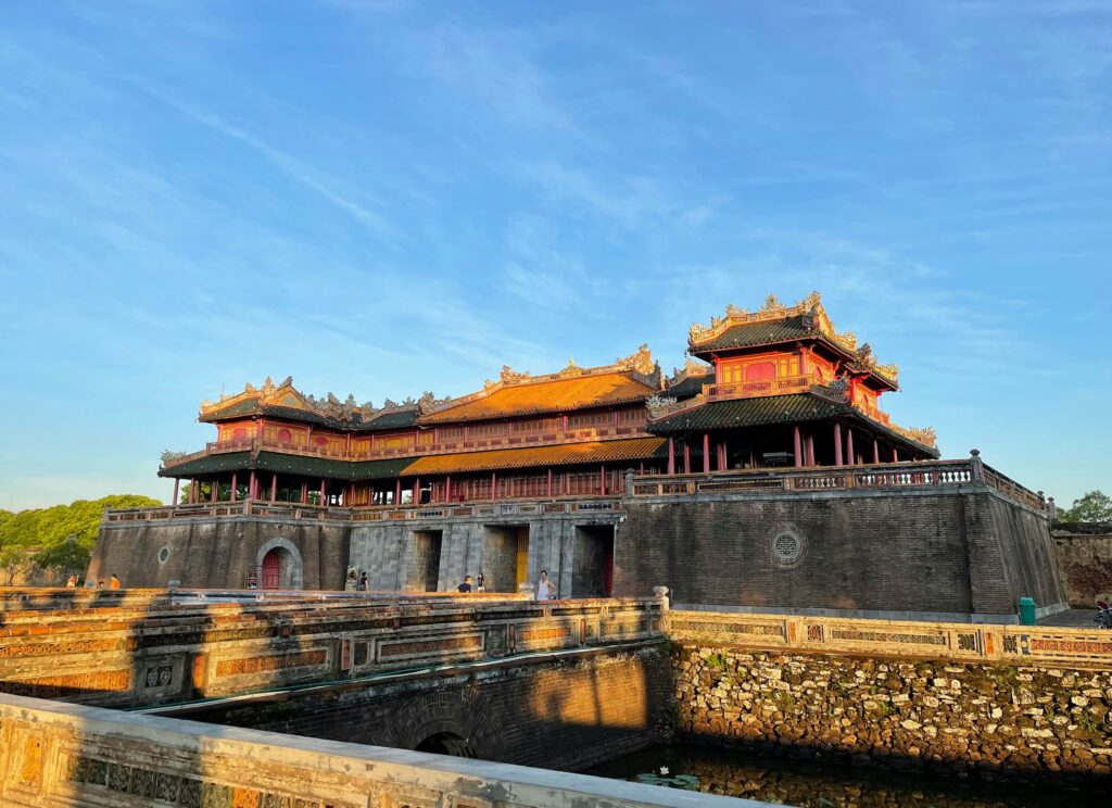 The historic Imperial City in Hue, Vietnam, showcasing ancient citadel gates, ornate architecture, and lush surrounding gardens on a clear day.