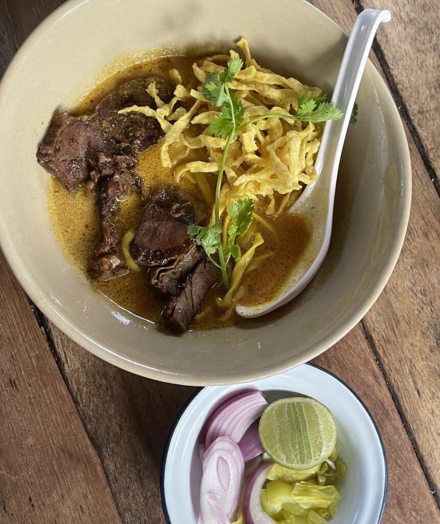A beautifully plated Khao Soi from Michelin-rated Kao Soy Nimman in Chiang Mai, featuring a lighter coconut broth and delicate noodles.
