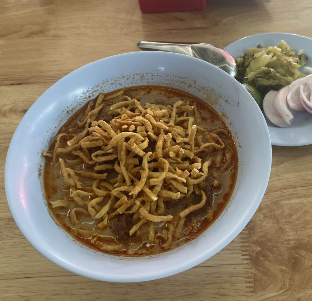 Khao Soi from Lung Prakit, a Michelin-rated spot in southern Chiang Mai, featuring a spicier coconut curry broth with condiments on the side.
