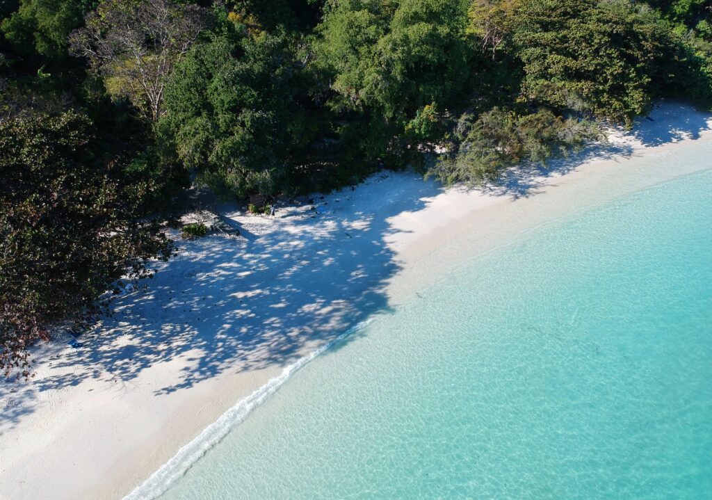Clear blue water on a calm, remote beach in Koh Samet, Thailand on a sunny day
